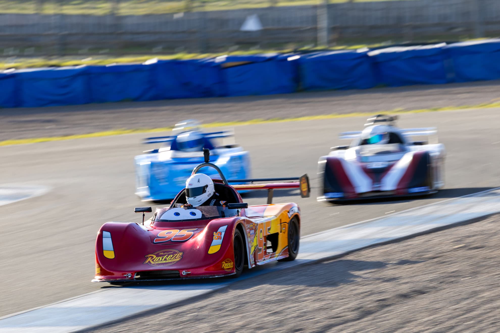 Race car rolling out under neon reflections